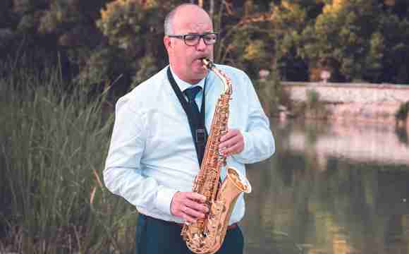 Saxofonista MA creando un ambiente elegante durante un cóctel.