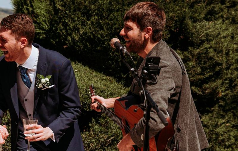 Cantante acústico ofreciendo música en vivo en un cóctel de boda en la zona centro