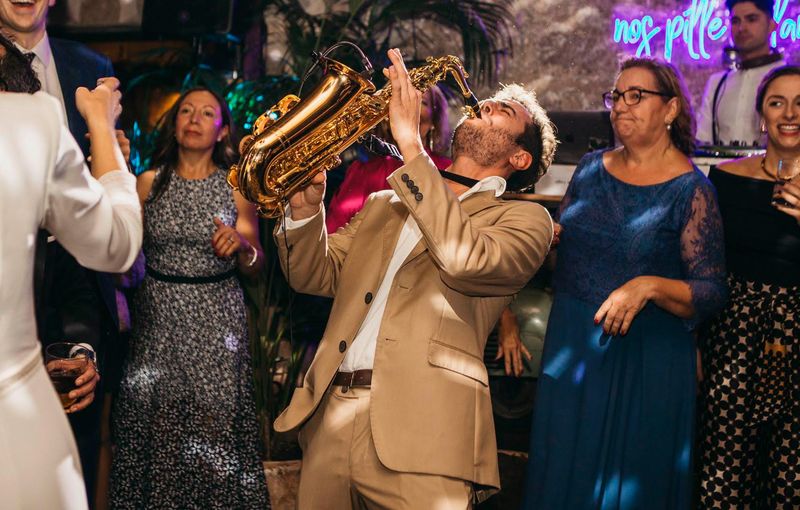 DJ y saxofonista creando ambiente festivo en barra libre